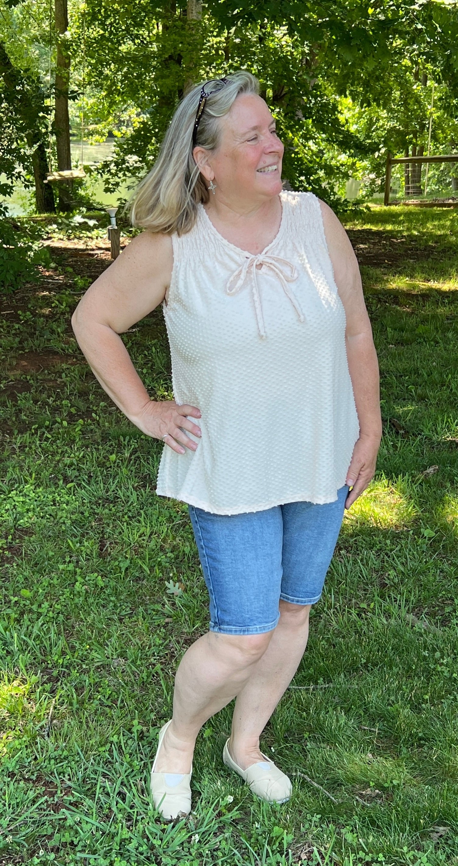 Peach Whisper Blouse features a swiss dot feel to the soft fabric, a round neck with tie, flowy bodice, and is sleeveless.  Available in Small to X-Large.